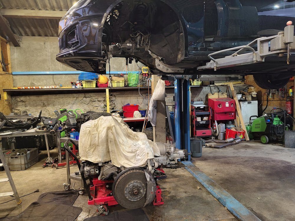 L'atelier : véhicule sur le pont, moteur déposé